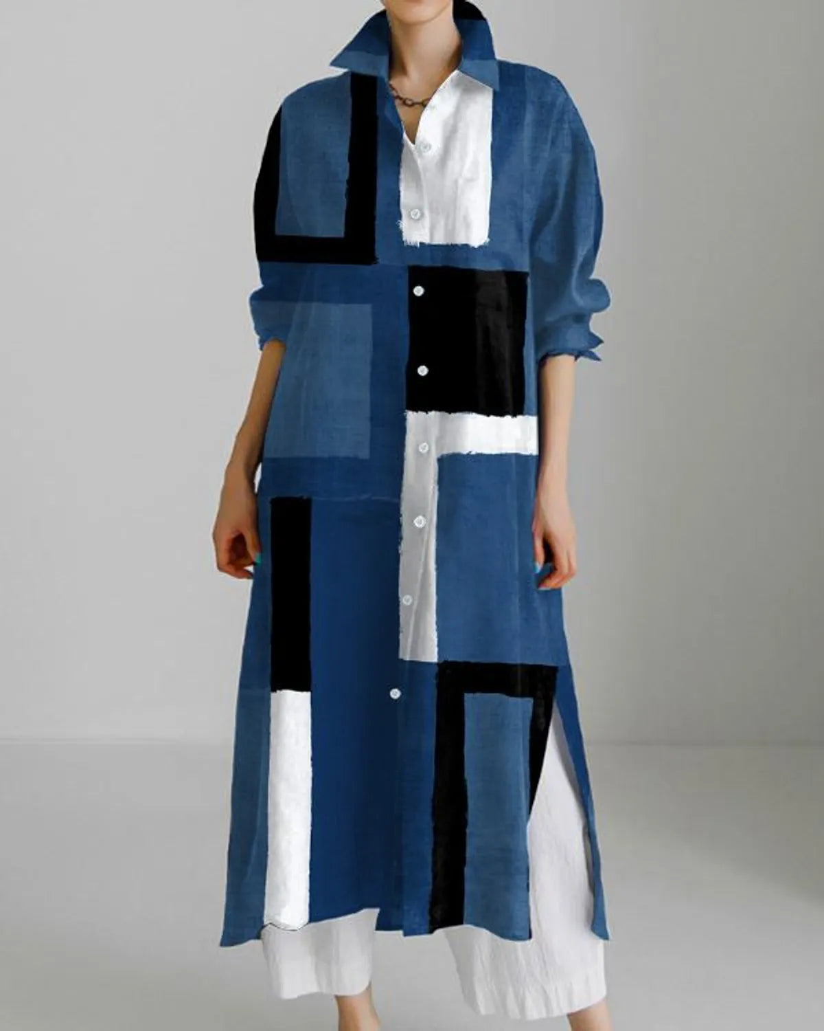 A long indigo shirt dress with geometric blue color designs, featuring a collar, button-up front, and a maxi-length silhouette.